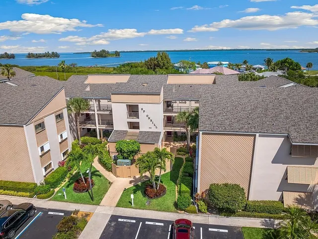an aerial view of residential houses with outdoor space and ocean view
