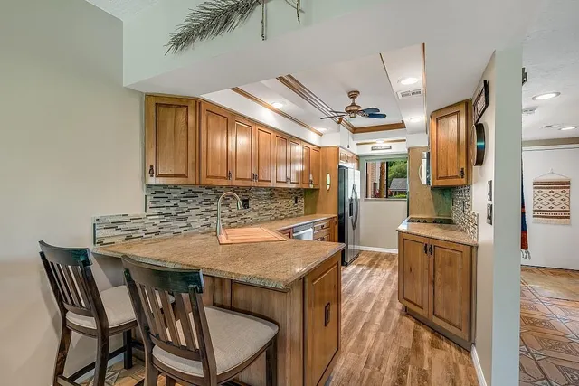 a kitchen with granite countertop a stove a sink and chairs