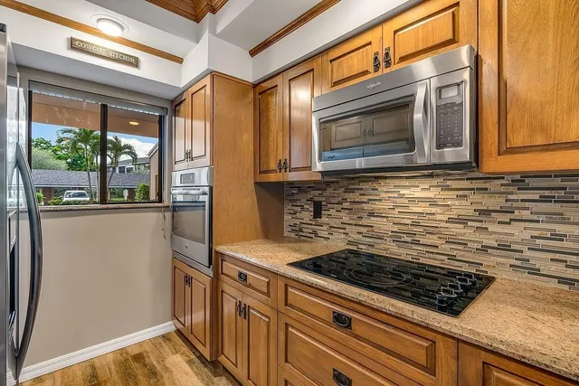 a kitchen with stainless steel appliances granite countertop a refrigerator and a stove