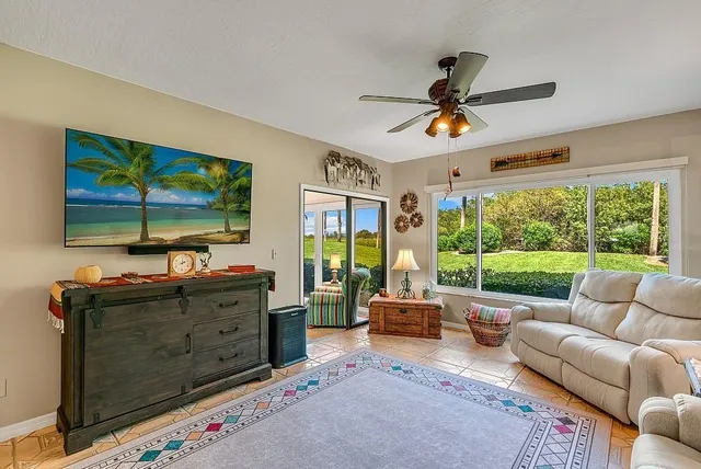 a living room with furniture flat screen tv and a large window