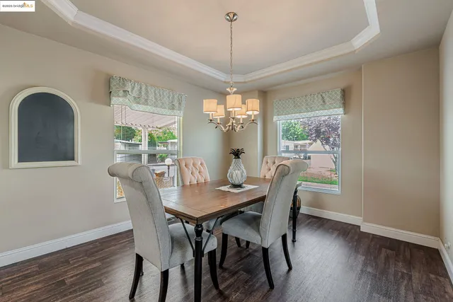 a dining room with furniture a chandelier and wooden floor