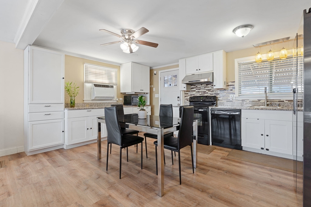 2 Brandywine Drive Hooksett, NH 03106 - Photo 8 of 42 a kitchen with stainless steel appliances kitchen island granite countertop a stove top oven a sink a dining table and chairs with wooden floor