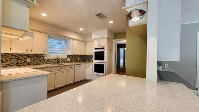 a large kitchen with stainless steel appliances granite countertop a refrigerator and a stove top oven