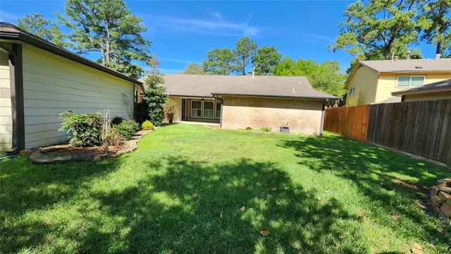 a view of a house with a yard and a tree
