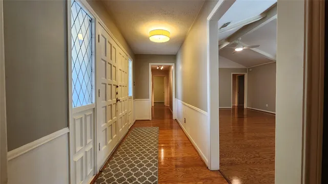 a view of a hallway with wooden floor and staircase