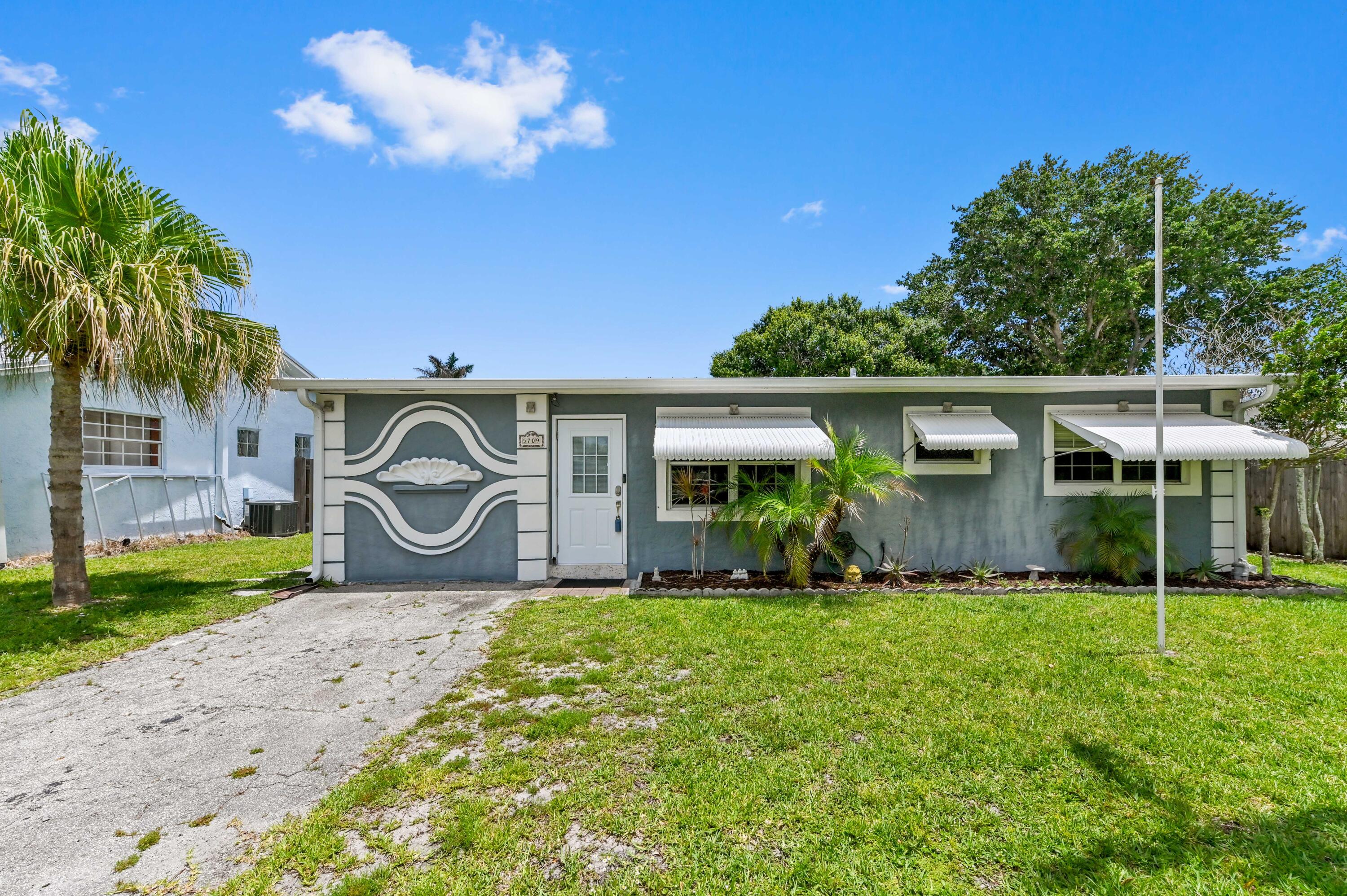 5709 Southeast Indigo Avenue Stuart, FL 34997 - Photo 3 of 26 a front view of a house with garden