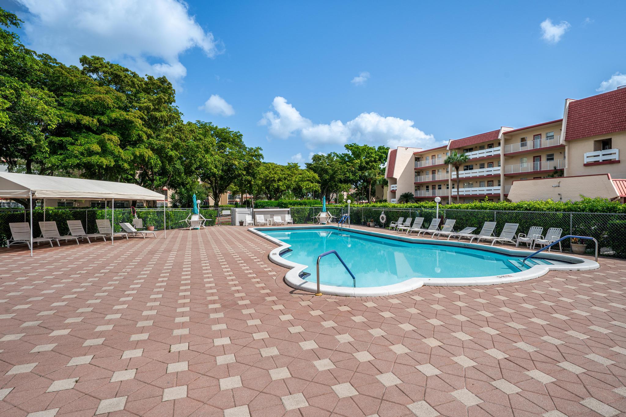 1010 Country Club Drive, Unit 108 Margate, FL 33063 - Photo 17 of 19 a view of a swimming pool and a yard