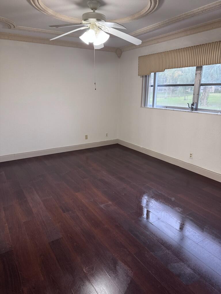 1010 Country Club Drive, Unit 108 Margate, FL 33063 - Photo 5 of 19 an empty room with wooden floor and windows