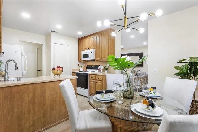 a view of a dining room and kitchen with furniture wooden floor and a chandelier