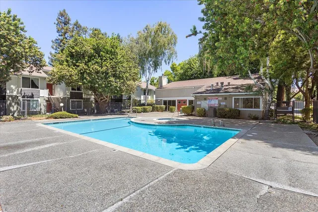 a view of a white house with a swimming pool and sitting area