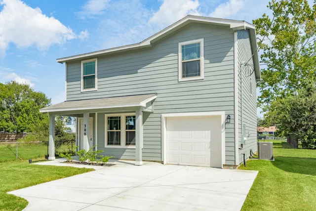 a front view of a house with a garden and yard