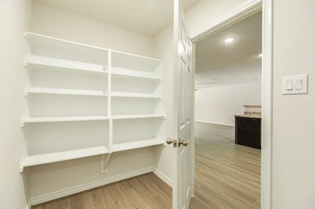a view of walk in closet with empty racks