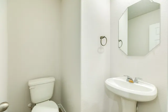 a bathroom with a sink a toilet and mirror