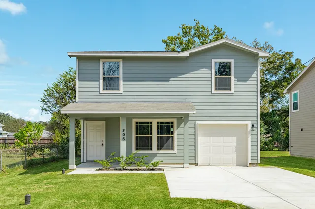 a front view of a house with a yard and trees