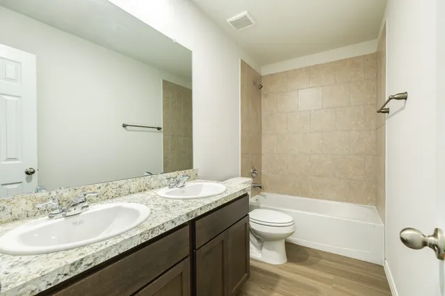 a bathroom with a granite countertop sink toilet and shower