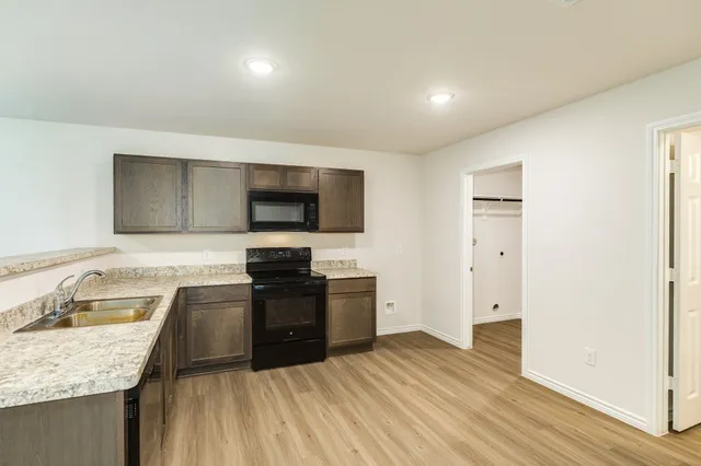 a kitchen with granite countertop stainless steel appliances and wooden cabinets