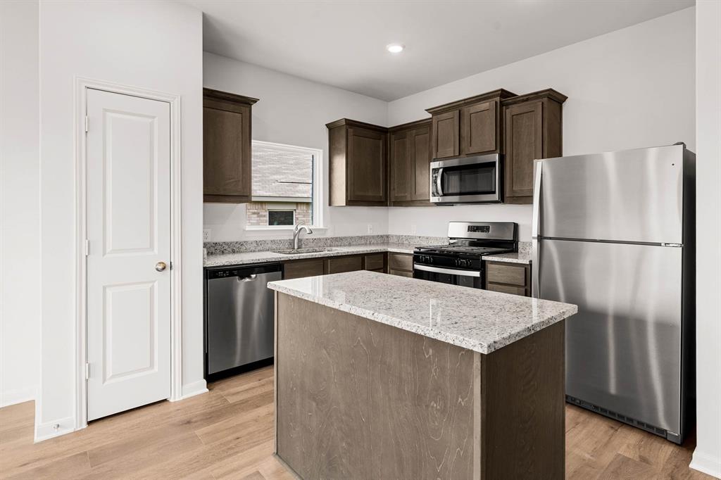 213 Julian Davis Drive Venus, TX 76084 - Photo 3 of 9 a kitchen with stainless steel appliances granite countertop a refrigerator a stove a sink and a microwave