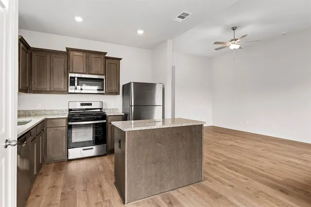 a kitchen with kitchen island a counter top space appliances and cabinets