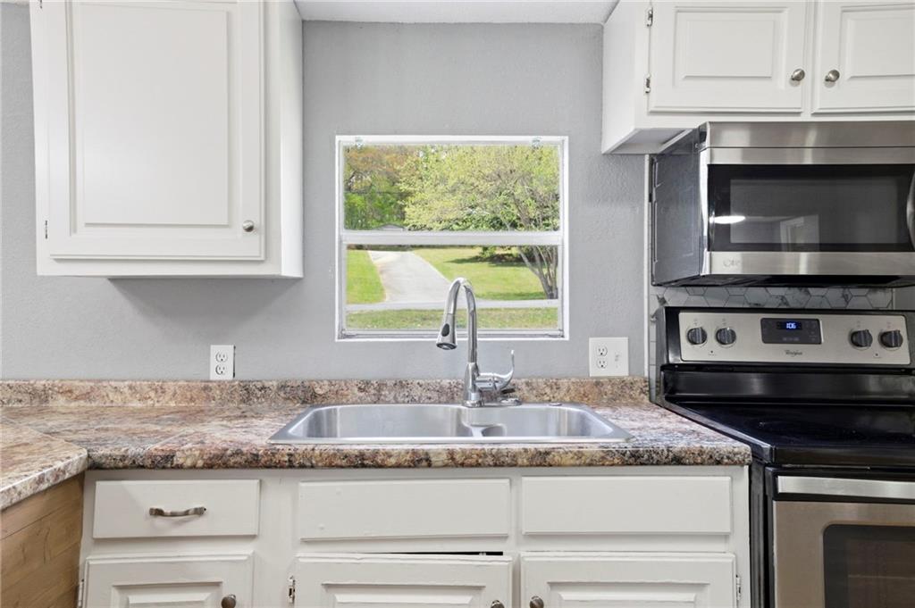 109 Webb Drive Northeast Calhoun, GA 30701 - Photo 24 of 49 a kitchen with granite countertop a stove and a sink