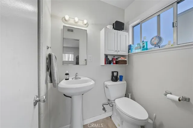 a bathroom with a sink mirror toilet and a window
