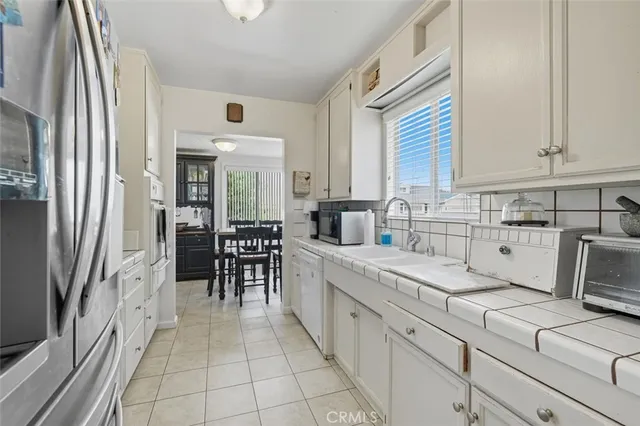a large white kitchen with cabinets
