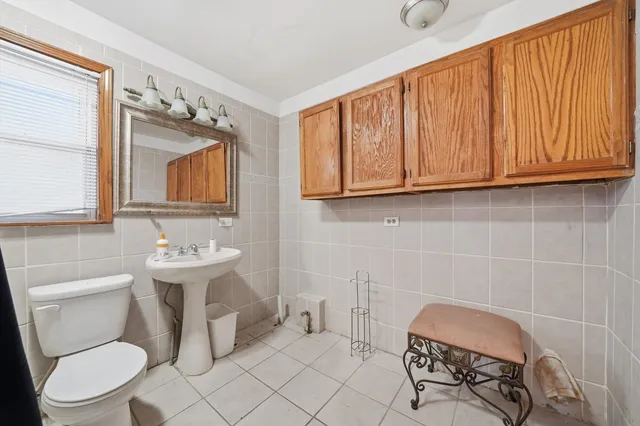 a bathroom with a toilet a sink and a mirror