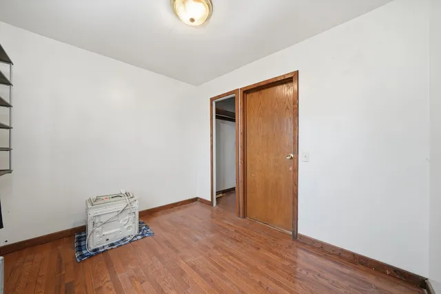 an empty room with wooden floor and mirror