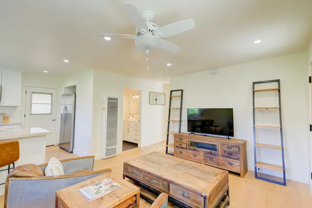 a large white kitchen with sink and a refrigerator