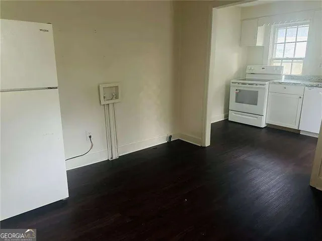a kitchen with granite countertop a stove and wooden floor