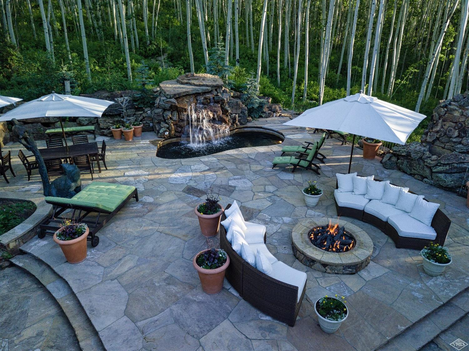 1944 Sunburst Drive, Unit A&B Vail, CO 81657 - Photo 25 of 37 a view of a backyard with table and chairs under an umbrella