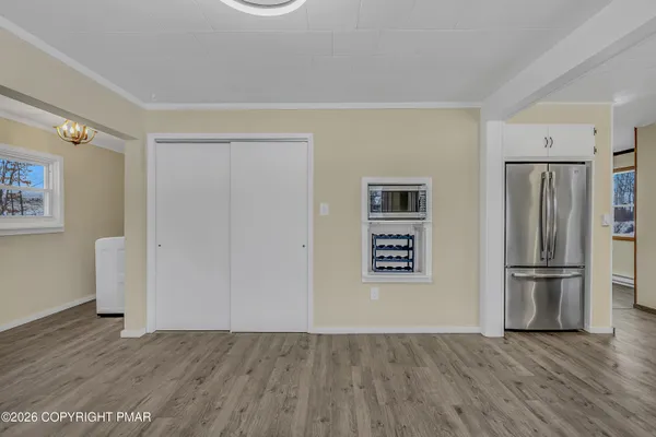 a view of kitchen with wooden floor electronic appliances and window