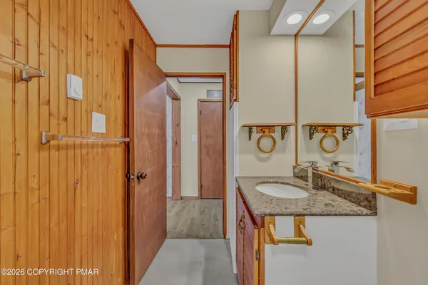 a bathroom with a granite countertop sink and a mirror