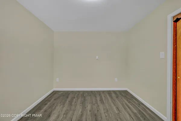 a view of an empty room with wooden floor