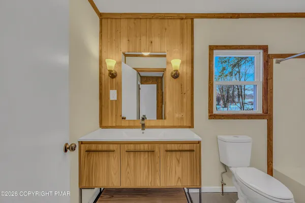 a bathroom with a toilet a sink and mirror
