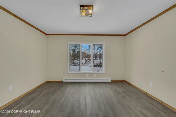 an empty room with wooden floor and a window