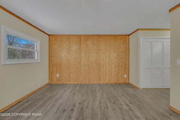an empty room with wooden floor and a window