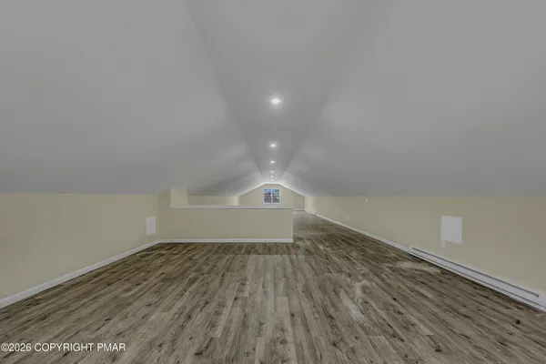 a view of empty room with wooden floor