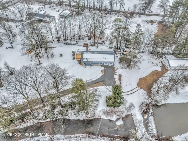 a front view of a house with a yard covered with snow