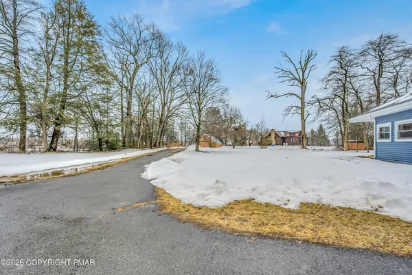 a view of a house with a yard covered in snow