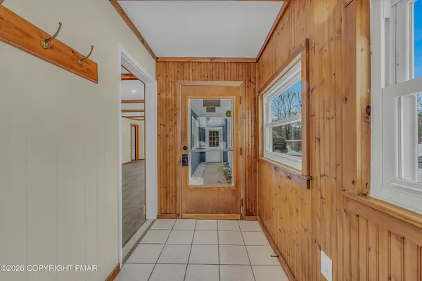 a view of a hallway with wooden floor and a bathroom