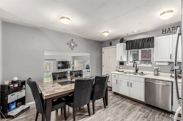 a kitchen with a table chairs sink and cabinets