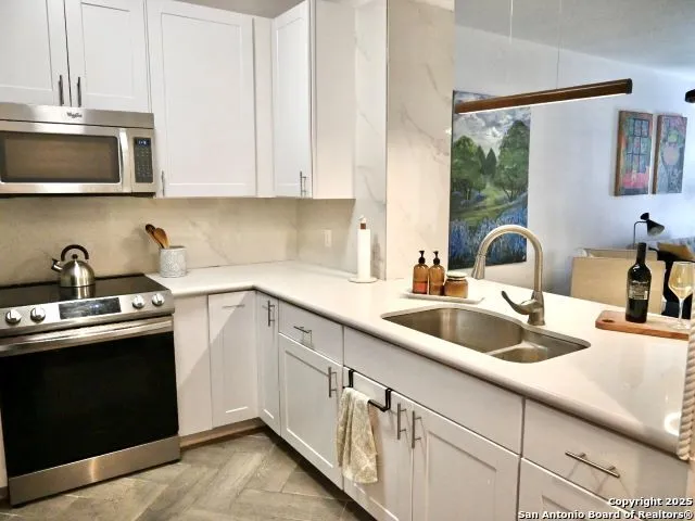 a kitchen with a sink a stove and cabinets