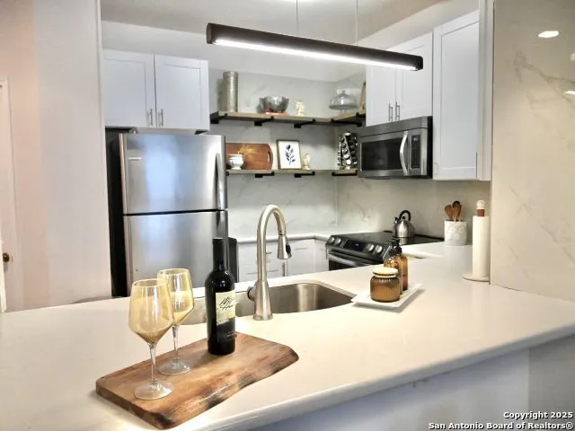 a kitchen with stainless steel appliances granite countertop a refrigerator sink and stove