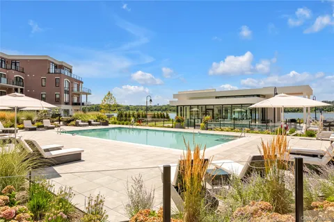 a view of a swimming pool with furniture and a yard