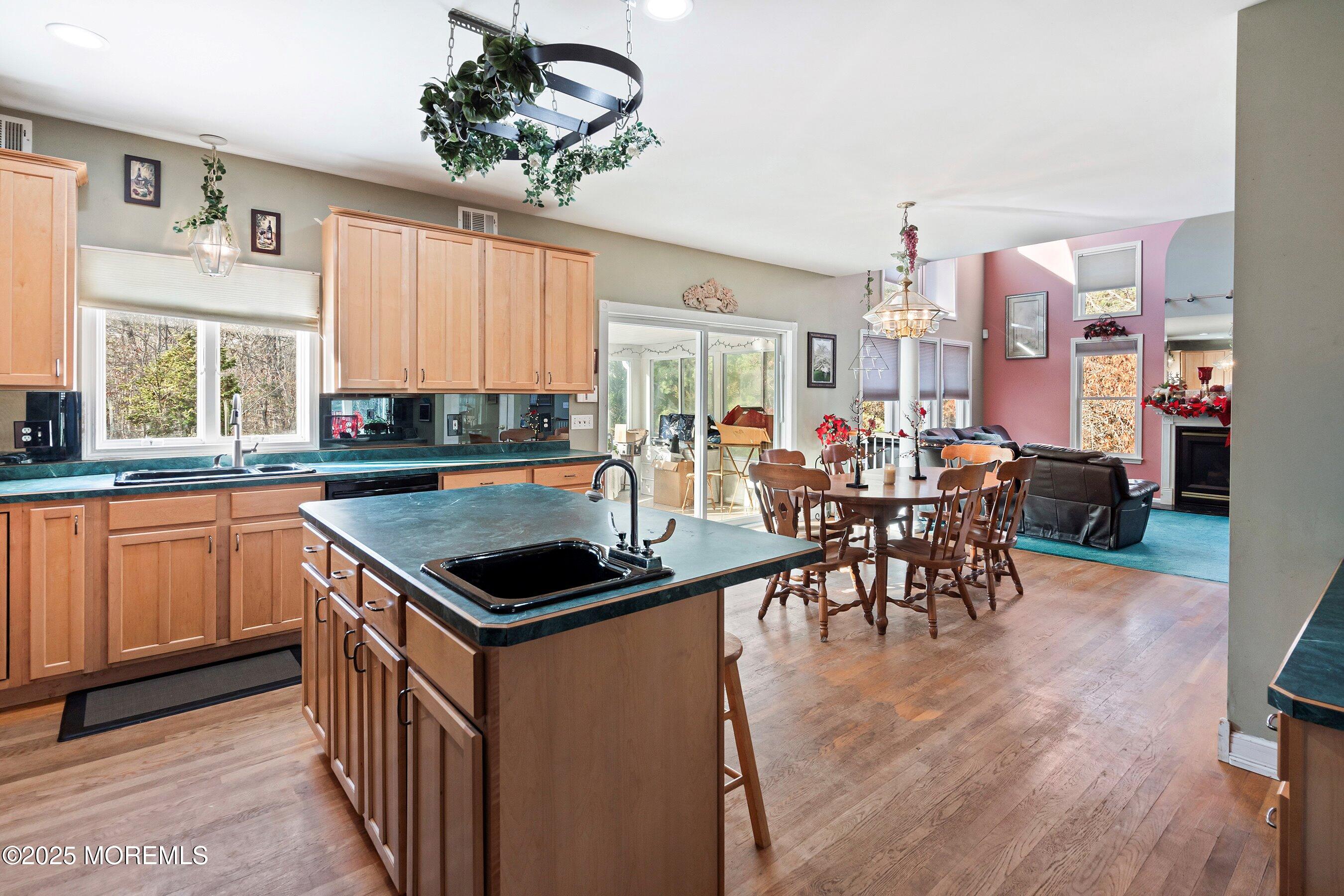 9 Ranch Boulevard Manahawkin, NJ 08050 - Photo 27 of 55 a kitchen with stainless steel appliances kitchen island granite countertop a table chairs in it and wooden floors