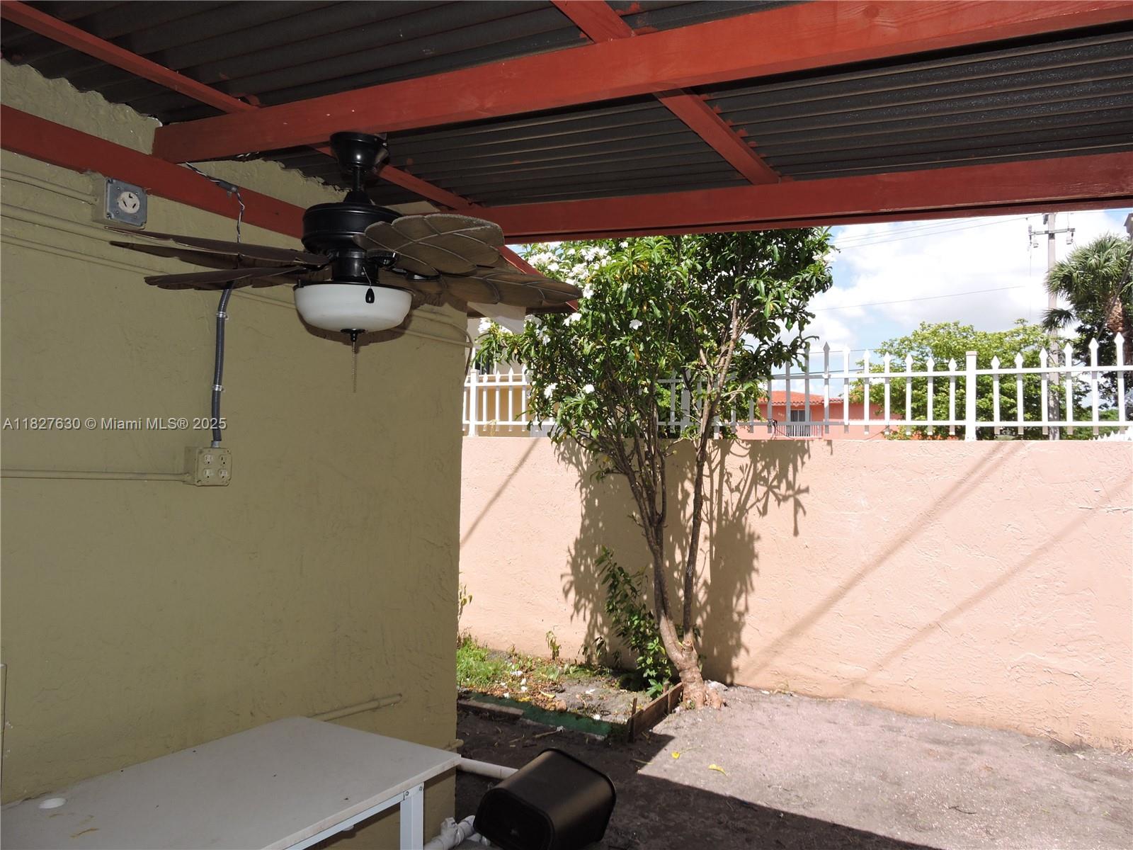 525 East 24th Street, Unit 4 Hialeah, FL 33013 - Photo 15 of 17 a view of a patio with table and chairs under an umbrella with a small yard
