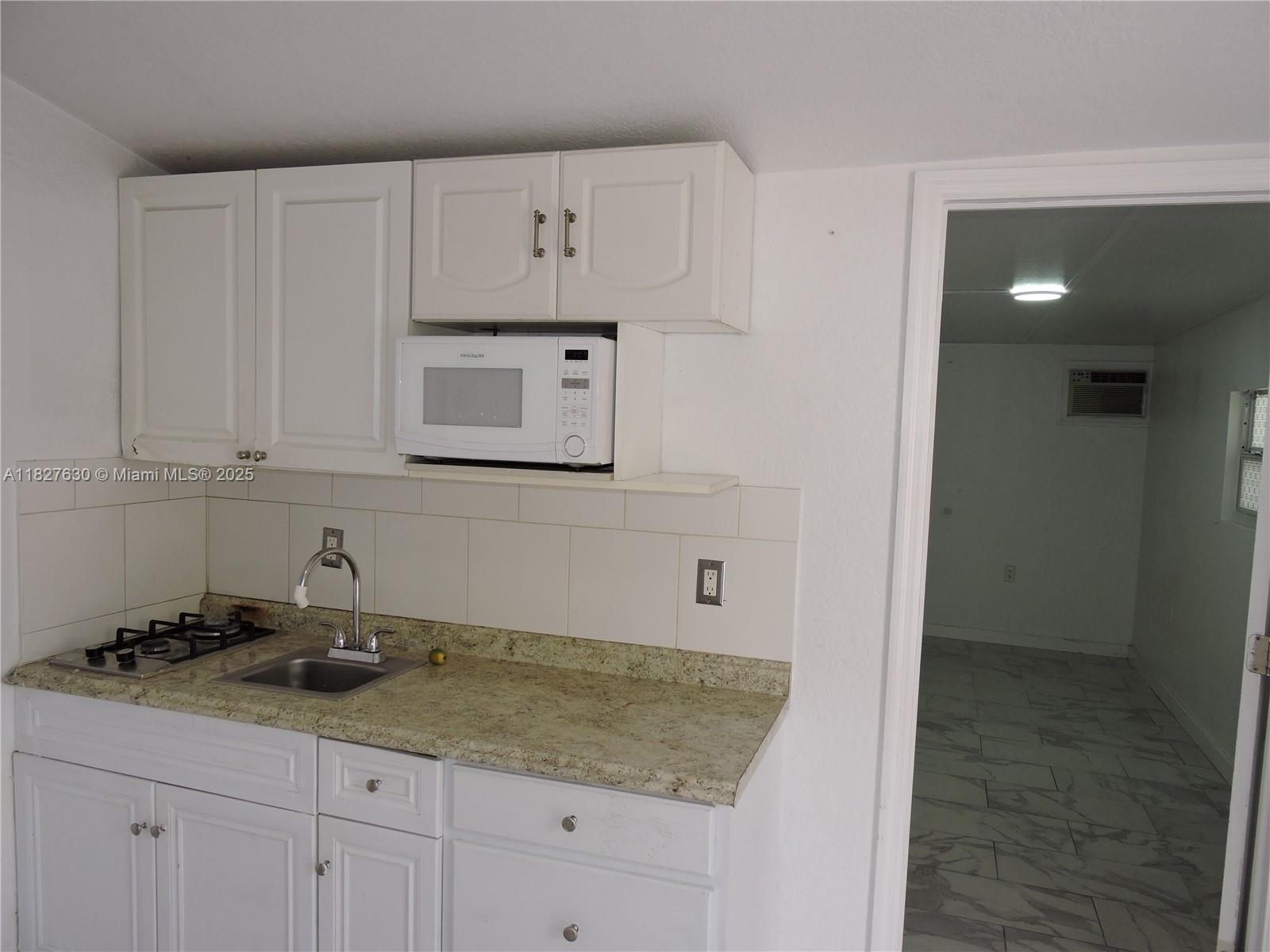 525 East 24th Street, Unit 4 Hialeah, FL 33013 - Photo 8 of 17 a kitchen with granite countertop white cabinets and sink