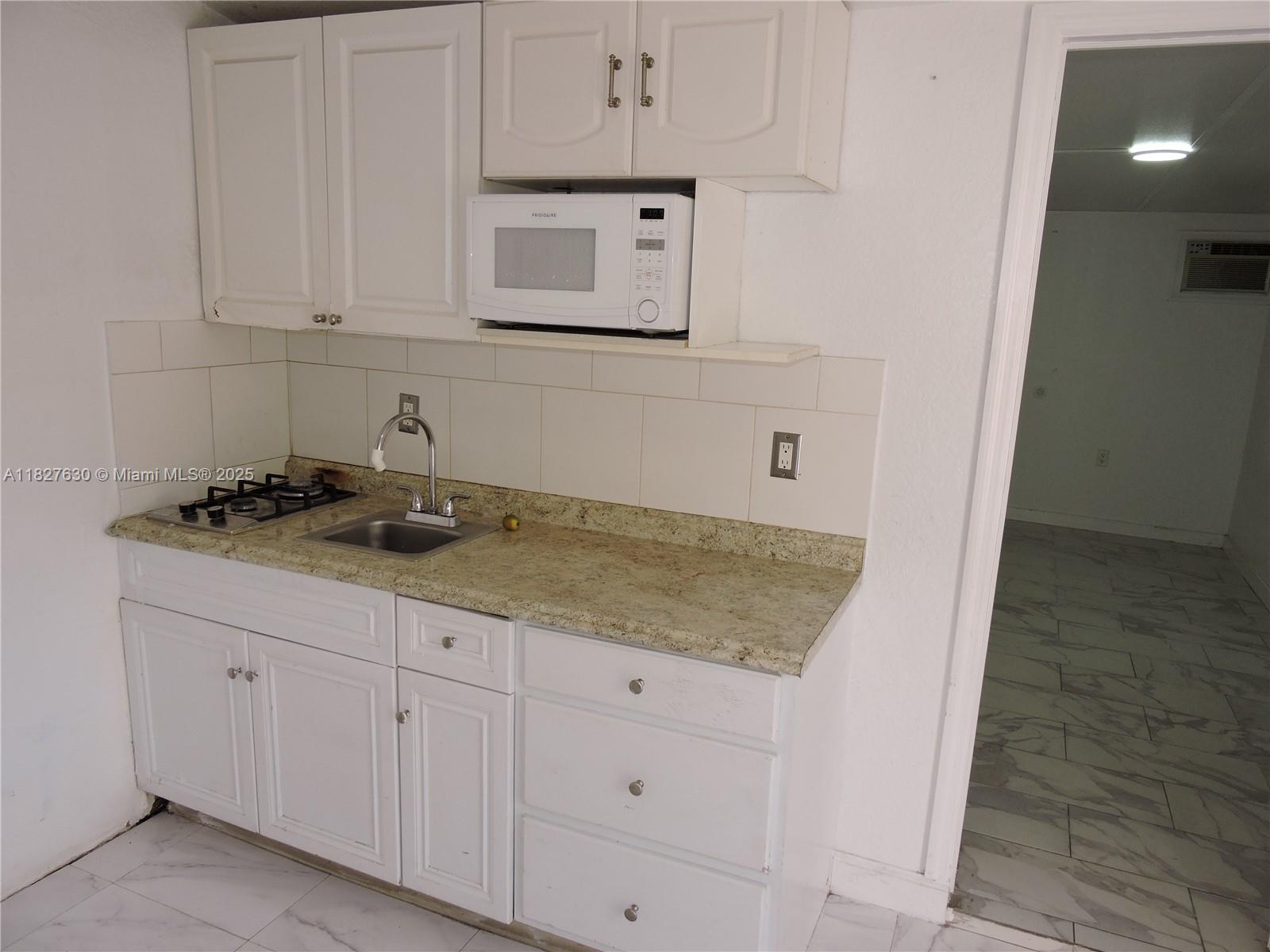 525 East 24th Street, Unit 4 Hialeah, FL 33013 - Photo 9 of 17 a kitchen with granite countertop white cabinets and a sink