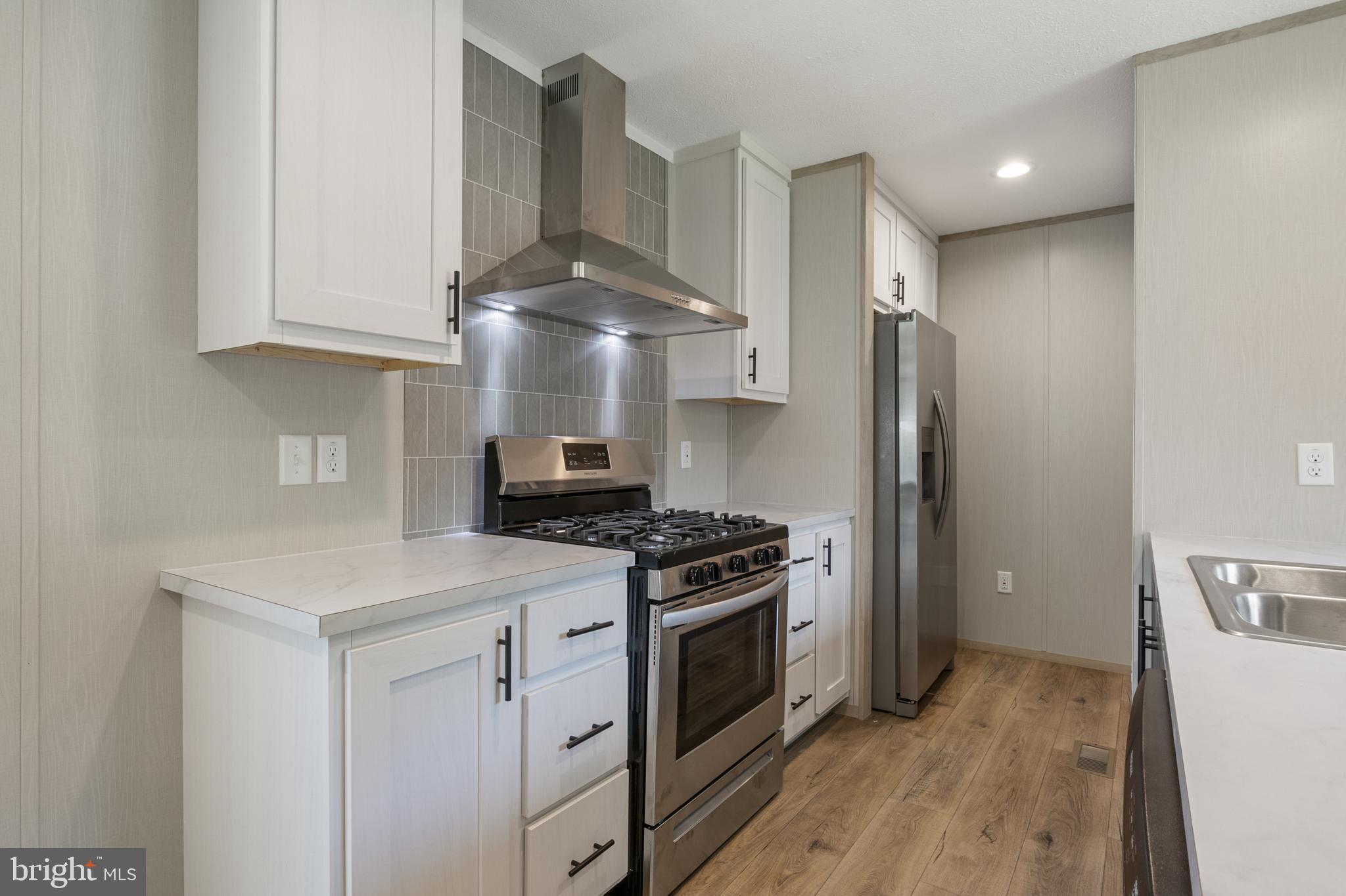 31 Mill Street York, PA 17406 - Photo 4 of 19 a kitchen with stainless steel appliances a stove a refrigerator and cabinets