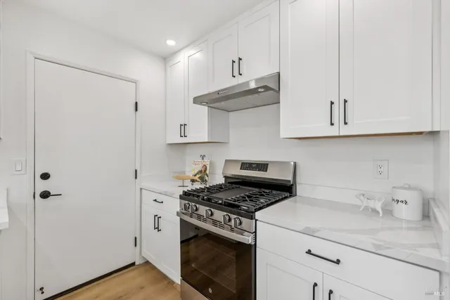a kitchen with a sink window and chairs
